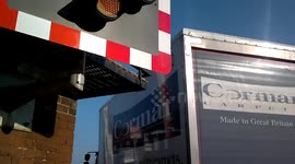 Lorry stops under level crossing barrier and has to reverse as crossing activates