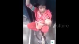 Mum cradles baby while sat between two speeding train carriages