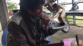 The blind man plays the guitar created by himself in the street