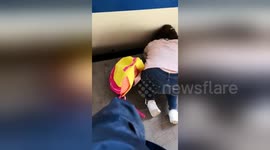 Girl falls between platform and train at Beijing station while mom glued to phone