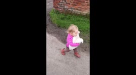 Toddler takes chicken for a walk.