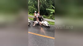 Motorcycle riders crash on slippery hill in tourist hotspot in Thailand