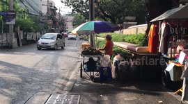 Boy relaxing in shade under mum's pineapple cart