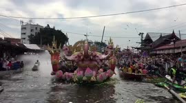 Thais mark the end of Buddhist Lent by throwing lotus flowers onto boats
