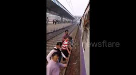Commuters in Mumbai board packed rush-hour train from the wrong side