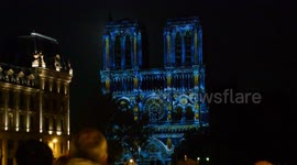 Parisians and tourist enjoy the hologram animation show on the facade of the Cathedrale Notre-Dame de Paris.(Real full moon in background). 23 october. 19h30