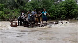 Villagers build rickety raft to go to work after bridge is washed away