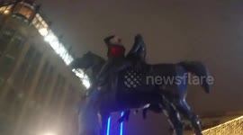 Someone putting the traffic cone on the statue at Glasgow's Royal Exchange Square