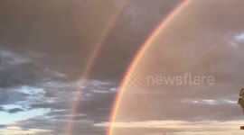 Beautiful double rainbow seen above Buddhist snake statue