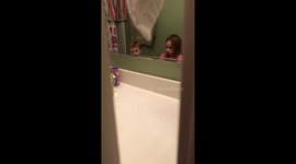 Sister helps baby brush her teeth