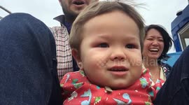 Two-year-old bursts into smiles going down slide with dad