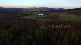 Aerial 4K view of autumn forest and mountains in the Scottish Highlands