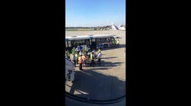 Drunk plane passenger being taken away by ambulance team after being tasered