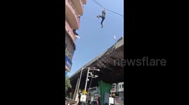 Shocking moment Indian man dangles from cable wire, falls to ground