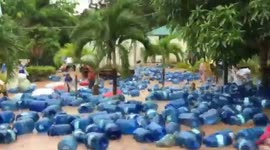 Hundreds of water dispensers float down flooded street after heavy downpour