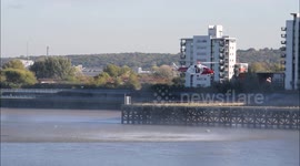 Coast Guard helicopter prepares to winch crew member from Lifeboat on the Thames at Woolwich