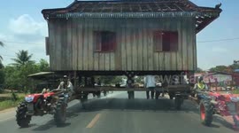 Cambodian villagers cause traffic chaos by moving wooden house along ENTIRE width of road