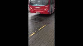 Bus rattles over square pothole