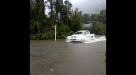 Wild weather in New Zealand: Man wakeboards behind truck in flooded street