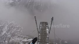 Man dives into the abyss wing-suiting through foggy Swiss valley