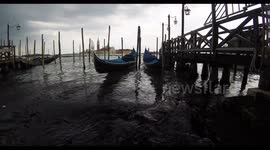Two Venetian gondolas shaking on the waves