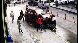 杭州  女子蹲车头前看手机被卷入车底 市民抬车营救