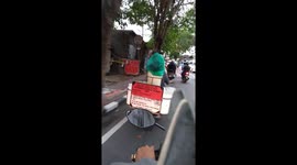Pet dog riding on the back of motorcycle while balancing on a bucket