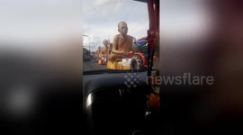 Driver captures procession of giant Buddhist monks statues on road
