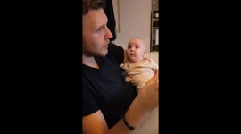Baby fascinated by father eating a pizza