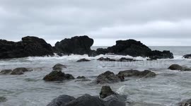 Waves washing over Rocks on a Beach