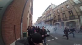 Protesters run from tear gas in Toulouse, France