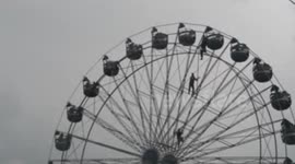 Girl dangles from fairground ride in Nepal