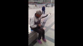 河北石家庄  老人街头用锯奏出音乐