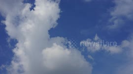White clouds moving over a blue sky.