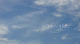 White clouds appear and disappear crossing a blue sky.