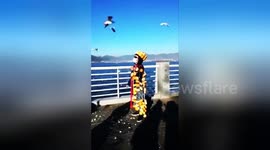 Strange man hangs bread on his body to attract seagulls
