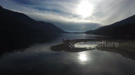 man skimming rocks across Canadian lake