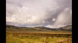 Time lapse shows clouds rolling over mountain landscape