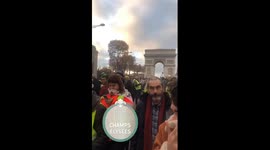 Smoke and tear gas hang in air as riot police face off with protesters in Paris