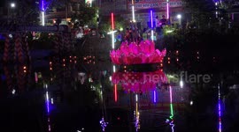 Giant lotus flower floats on a canal as people celebrate Loikratong festival.
