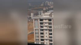 Person climbs out of 14th floor window to do spring cleaning on the balcony