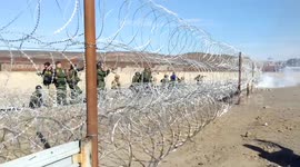 US border police lob tear gas over fence as migrant caravan approaches
