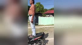 Motorists in Philippines amazed by elderly man standing on moving motorcycle