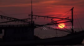 A beautiful sunset and rocking fishing boat with soothing sound of ocean waves.