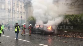 Firefighters extinguish blazing car during Paris
