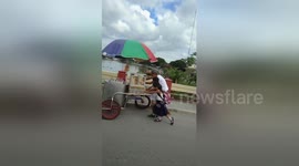 Tender moment schoolchildren help struggling elderly ice cream seller push cart up hill