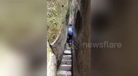 Man walks through incredible narrow passage through Chinese mountains
