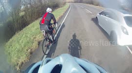 car passes close by cyclist