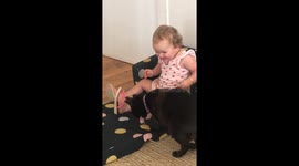 Baby girl sharing food with her cat