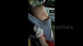 Cute baby having a sweet dream in Baby Carrier